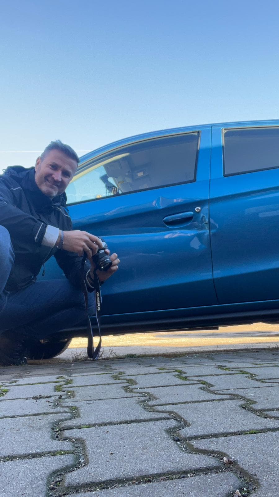 Sebastian Paul fotografiert eine eingedrückte Fahrertür an einem blauen Kleinwagen